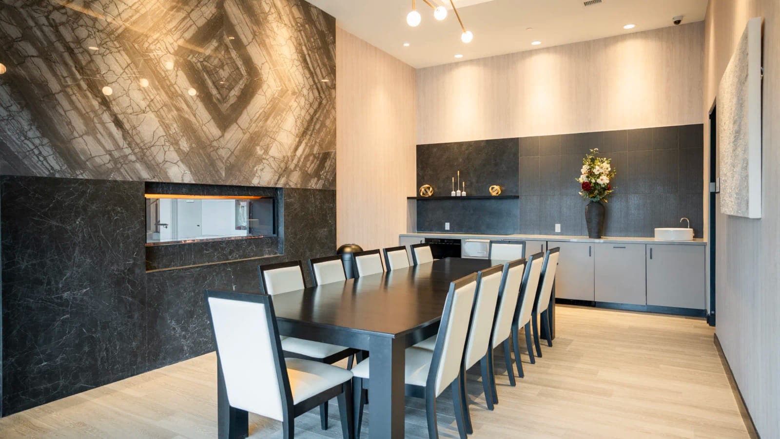 Private dining room with a long table and kitchen.